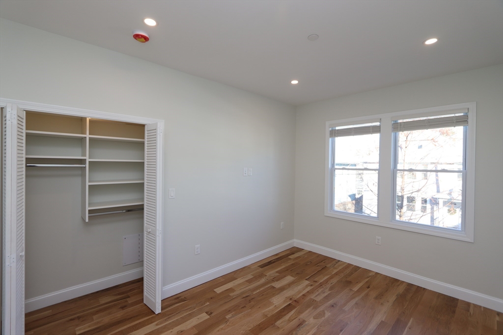 14-16 Harriet Street, Unit 1 Boston, MA 02135 - Photo 19 of 28 a view of empty room with wooden floor and fan