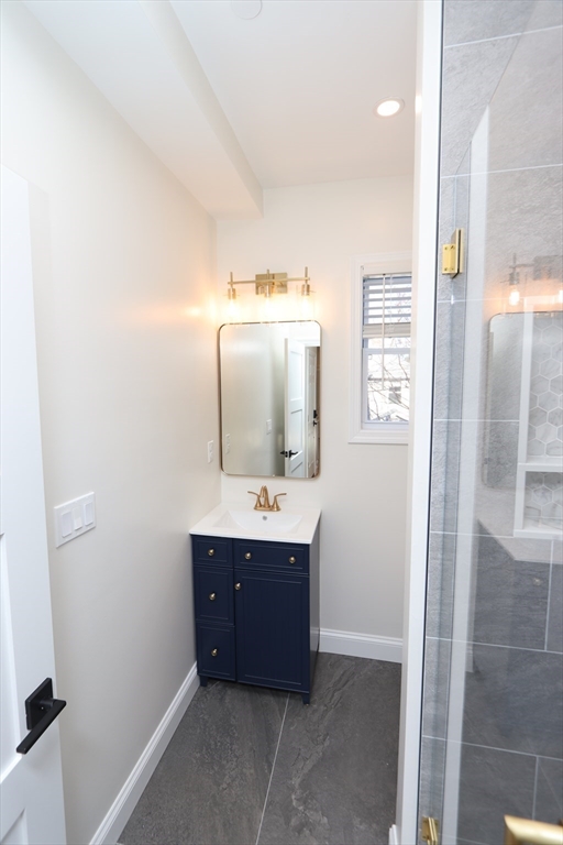 14-16 Harriet Street, Unit 1 Boston, MA 02135 - Photo 20 of 28 a bathroom with a double vanity sink and mirror with shower