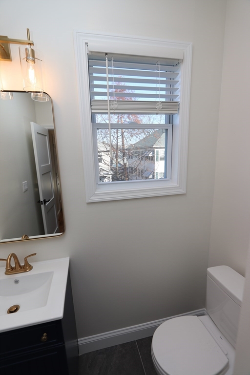 14-16 Harriet Street, Unit 1 Boston, MA 02135 - Photo 22 of 28 a bathroom with a toilet sink and mirror