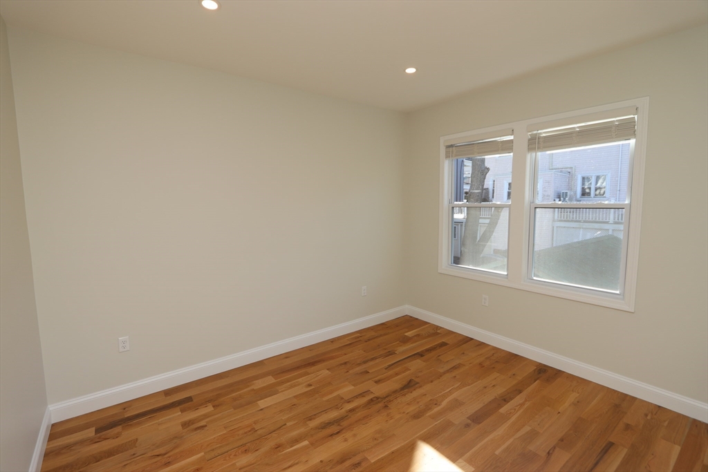 14-16 Harriet Street, Unit 1 Boston, MA 02135 - Photo 9 of 28 a view of empty room with wooden floor and fan