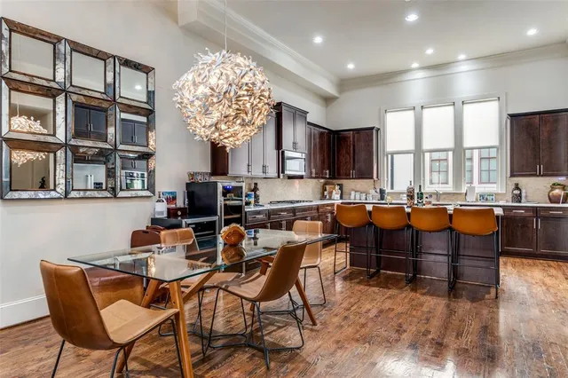 a dining hall with stainless steel appliances a table and chairs