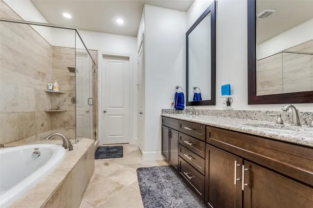 a spacious bathroom with a granite countertop tub sink a mirror and a shower