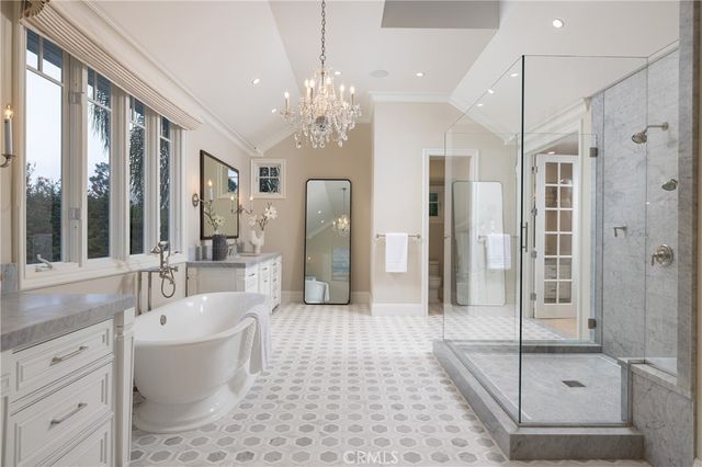 a spacious bathroom with a tub shower and mirror