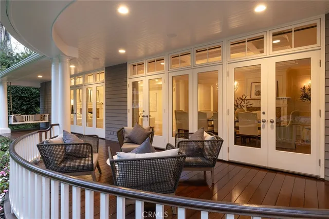 a dining room with furniture large windows and wooden floor