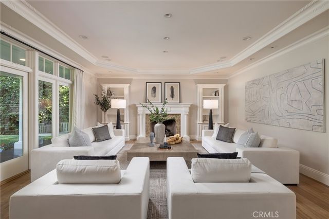 a living room with fireplace furniture and a large window