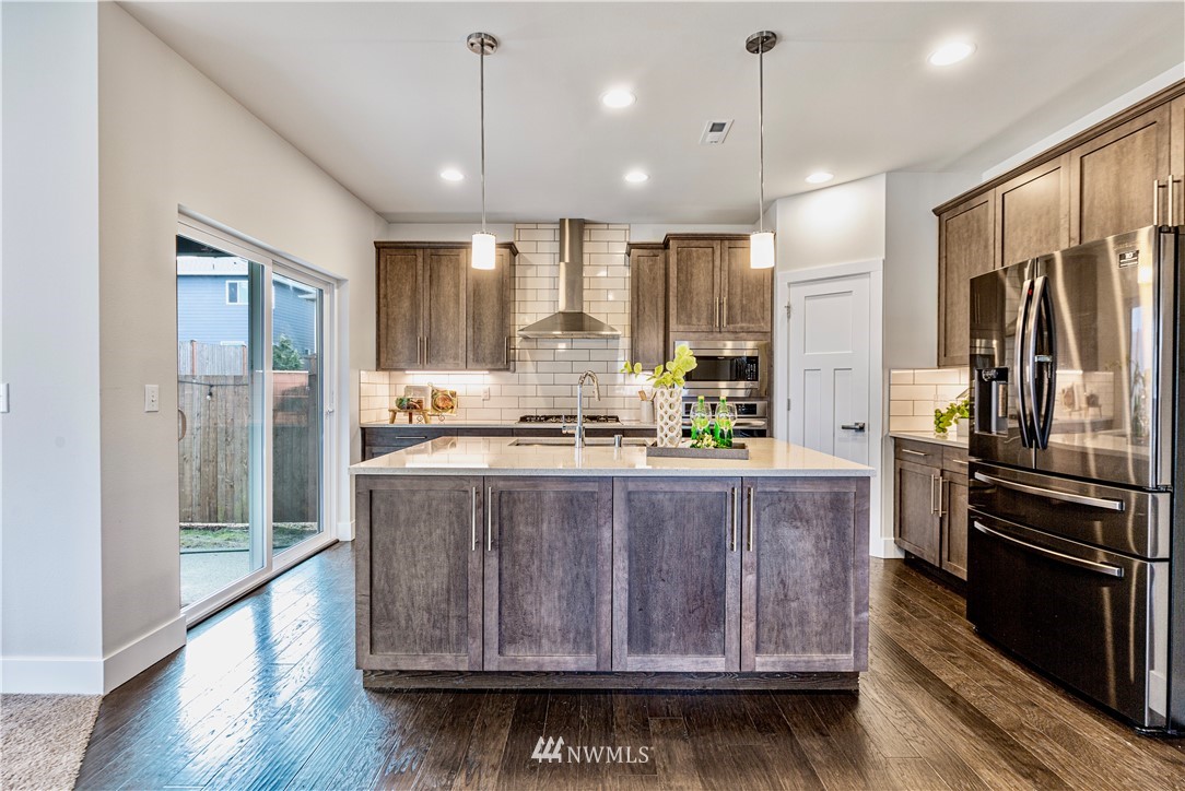 21325 43rd Drive Southeast Bothell, WA 98021 - Photo 12 of 32 a kitchen with stainless steel appliances granite countertop a refrigerator a sink and wooden floor
