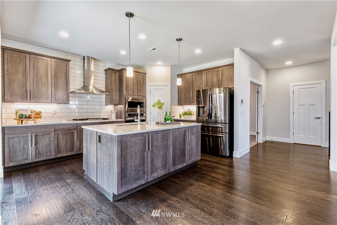 21325 43rd Drive Southeast Bothell, WA 98021 - Photo 13 of 32 a kitchen with stainless steel appliances granite countertop a refrigerator a sink dishwasher a stove and white cabinets with wooden floor