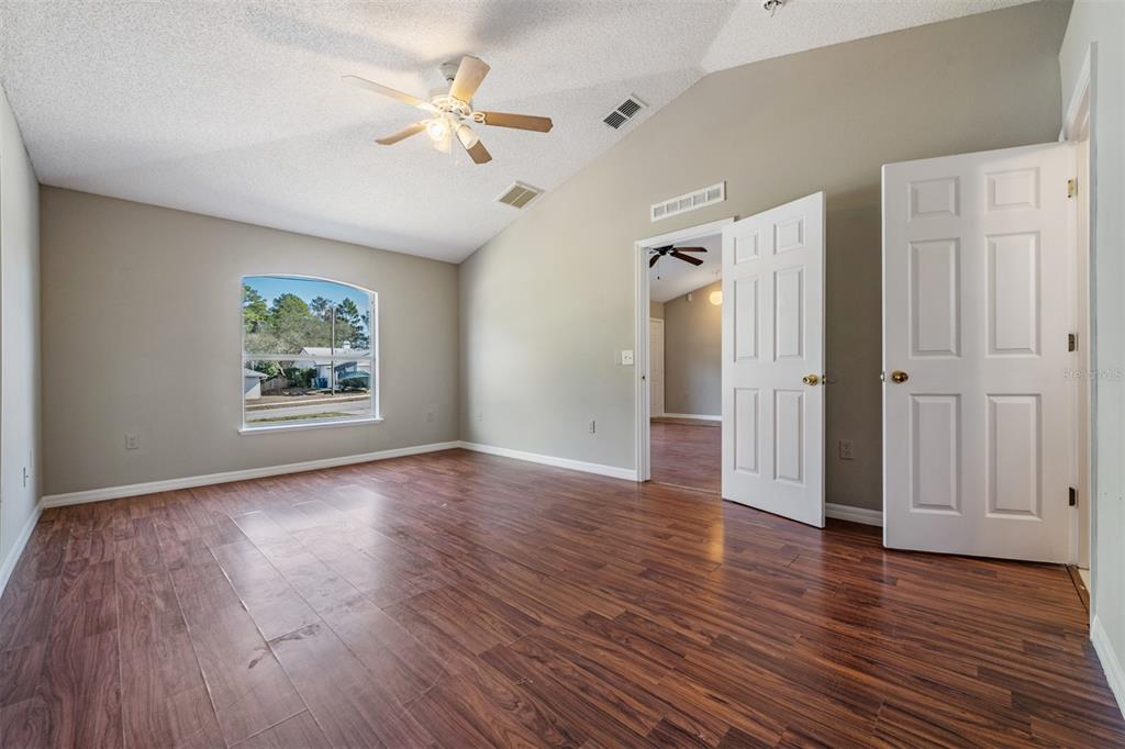 13364 Linden Drive Spring Hill, FL 34609 - Photo 16 of 28 an empty room with wooden floor chandelier fan and windows