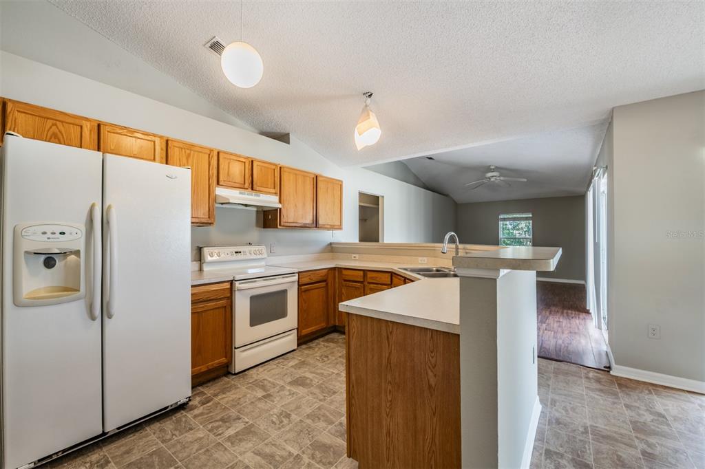 13364 Linden Drive Spring Hill, FL 34609 - Photo 8 of 28 a kitchen with stainless steel appliances granite countertop a refrigerator a sink dishwasher and a stove with white countertops