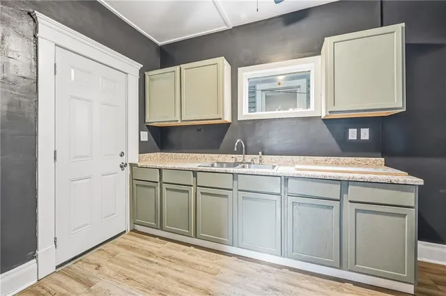 a kitchen with a sink cabinets and a wooden floor