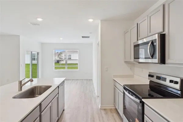 a kitchen with stainless steel appliances granite countertop a sink and a stove top oven