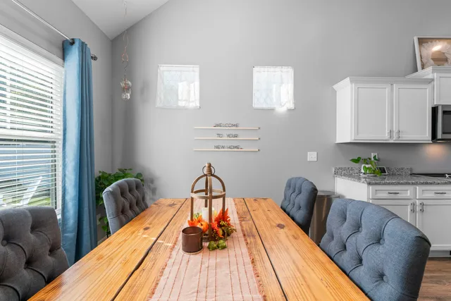 a kitchen with granite countertop kitchen island cabinets stainless steel appliances a sink and a dining table