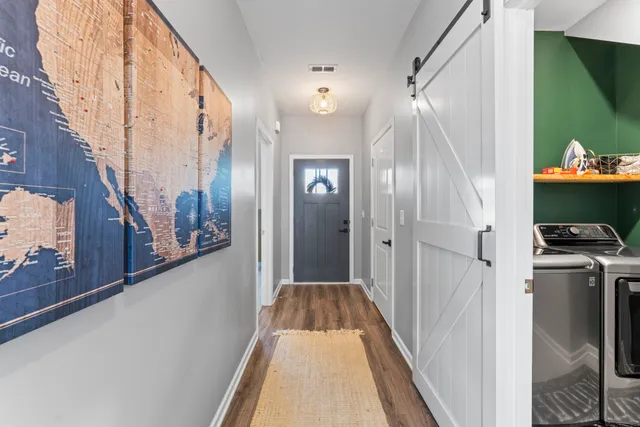a view of a hallway with wooden floor and staircase