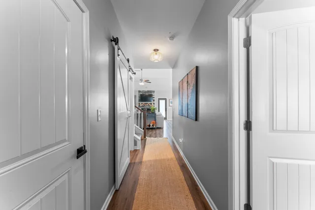a view of hallway with closet and wooden floor