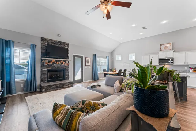 a living room with furniture a fireplace and a chandelier