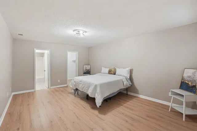 a bedroom with a bed and wooden floor