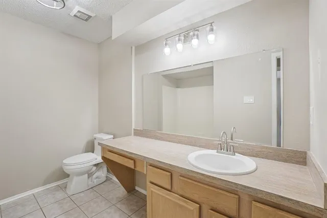 a bathroom with a granite countertop sink a toilet and a mirror
