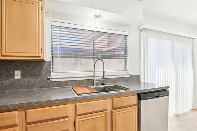 a kitchen with granite countertop white cabinets and window