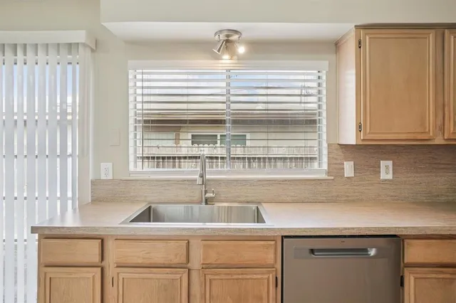 a kitchen with stainless steel appliances cabinets a window and a sink