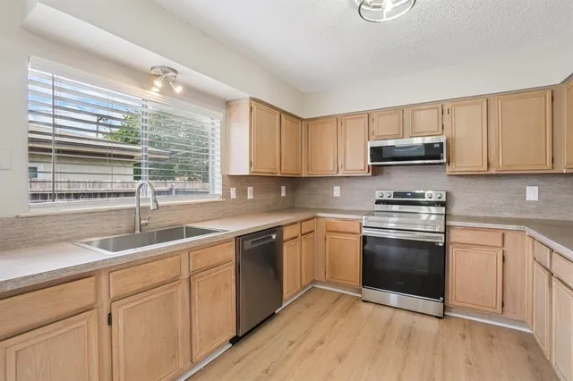 a kitchen with stainless steel appliances granite countertop a sink and a stove