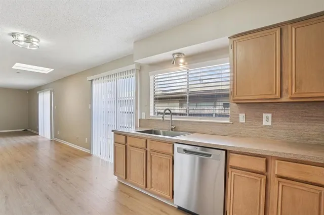 a kitchen with stainless steel appliances granite countertop a sink and dishwasher with wooden floor