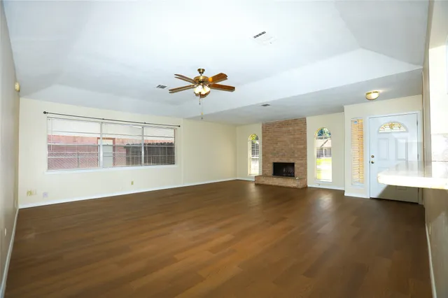 an empty room with wooden floor and fireplace