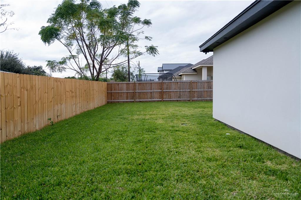 512 Spring Drive Alton, TX 78573 - Photo 17 of 18 a view of a backyard with potted plants and wooden fence