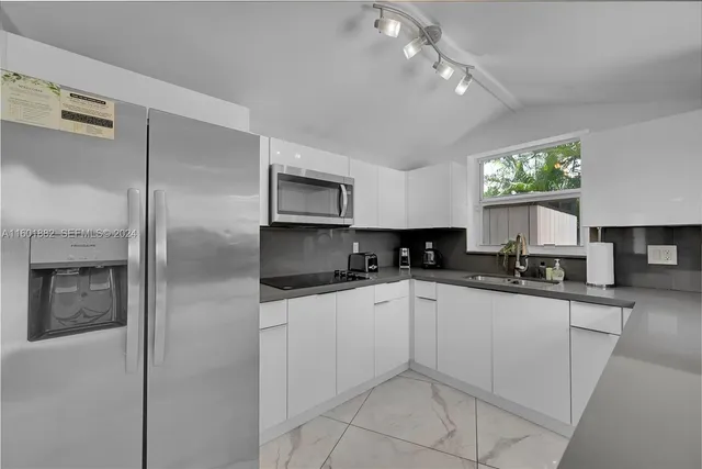 a kitchen with a sink stainless steel appliances and white cabinets