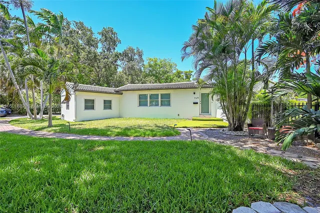 a view of a house with a backyard and a tree