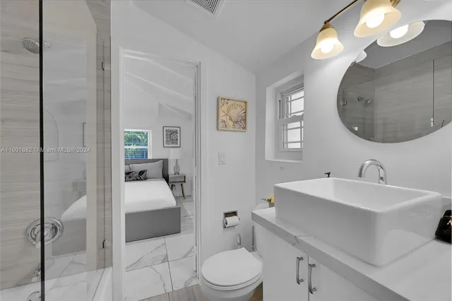 a en suite bathroom with a double vanity sink a mirror and a toilet