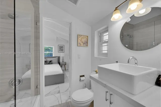 a en suite bathroom with a double vanity sink a mirror and a toilet