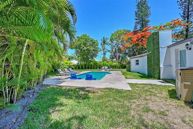 a view of a yard with plants and a tree