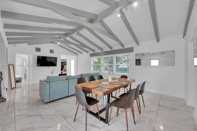 a view of a dining room with furniture and a flat screen tv