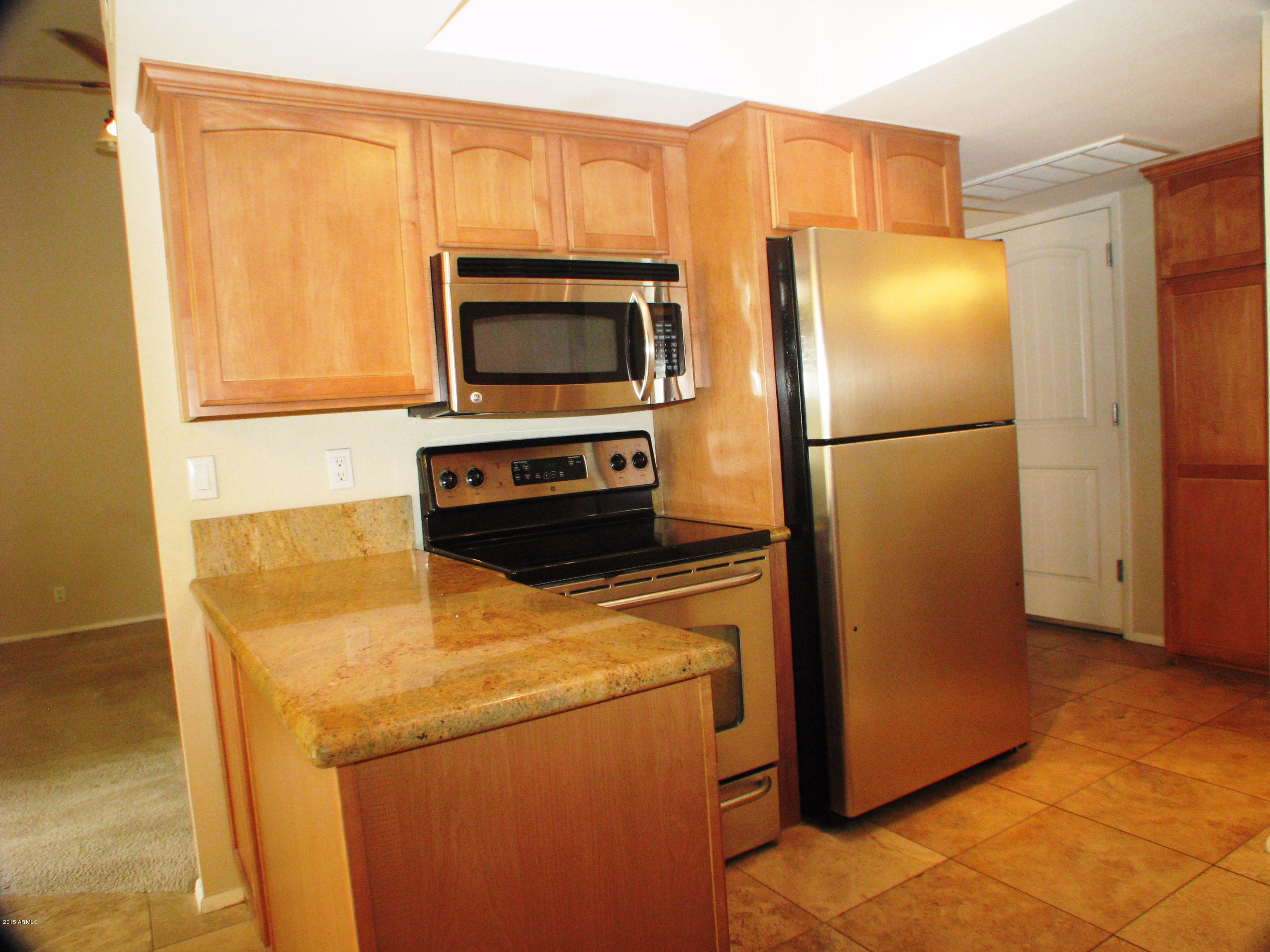 3807 North 30th Street, Unit 8 Phoenix, AZ 85016 - Photo 5 of 24 a kitchen with a refrigerator and a microwave