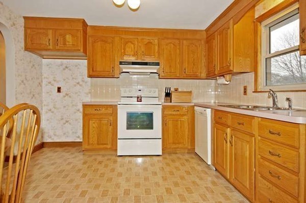 4 Thistle Road Woburn, MA 01801 - Photo 10 of 24 a kitchen with stainless steel appliances granite countertop a sink a stove a refrigerator with grey cabinets