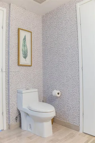 a white toilet sitting next to a shower