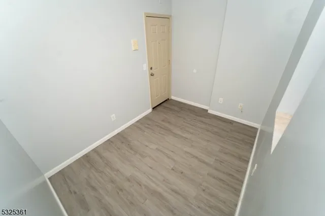 an empty room with wooden floor and white door