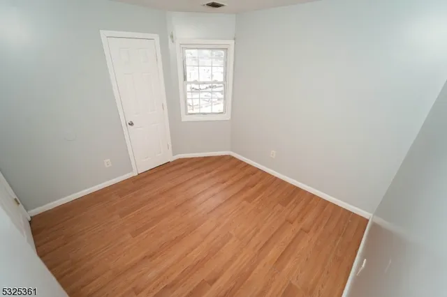 a view of a room with wooden floor and windows