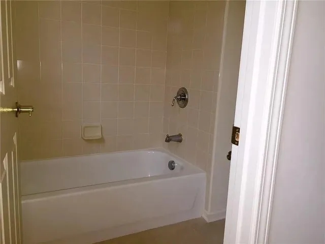 a white bath tub sitting next to a white wooden wall