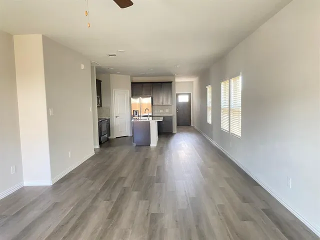 a view of empty room with wooden floor and window