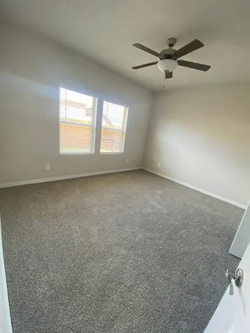 an empty room with windows and fan view