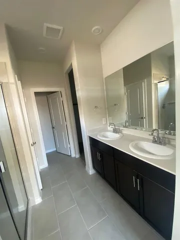 a bathroom with a double vanity sink and mirror