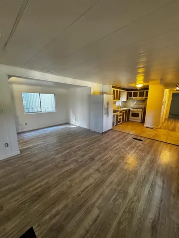 a view of empty room with wooden floor and window