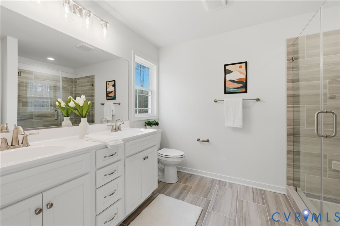 2460 Ballsville Road Powhatan, VA 23139 - Photo 23 of 28 a bathroom with a double vanity sink toilet and shower