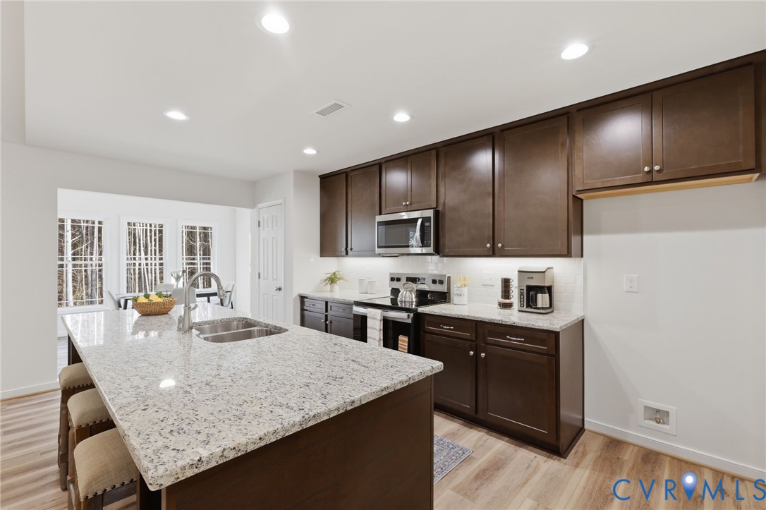 2460 Ballsville Road Powhatan, VA 23139 - Photo 9 of 28 a kitchen with granite countertop kitchen island stainless steel appliances a sink and a refrigerator