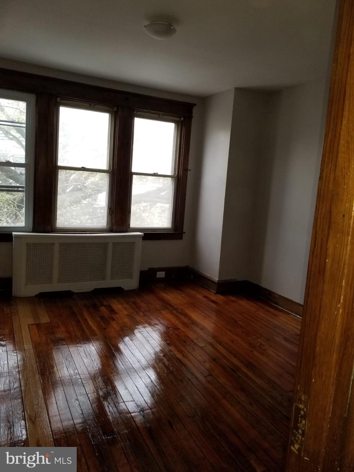 1264 Decatur Street Camden, NJ 08104 - Photo 4 of 9 an empty room with wooden floor and windows