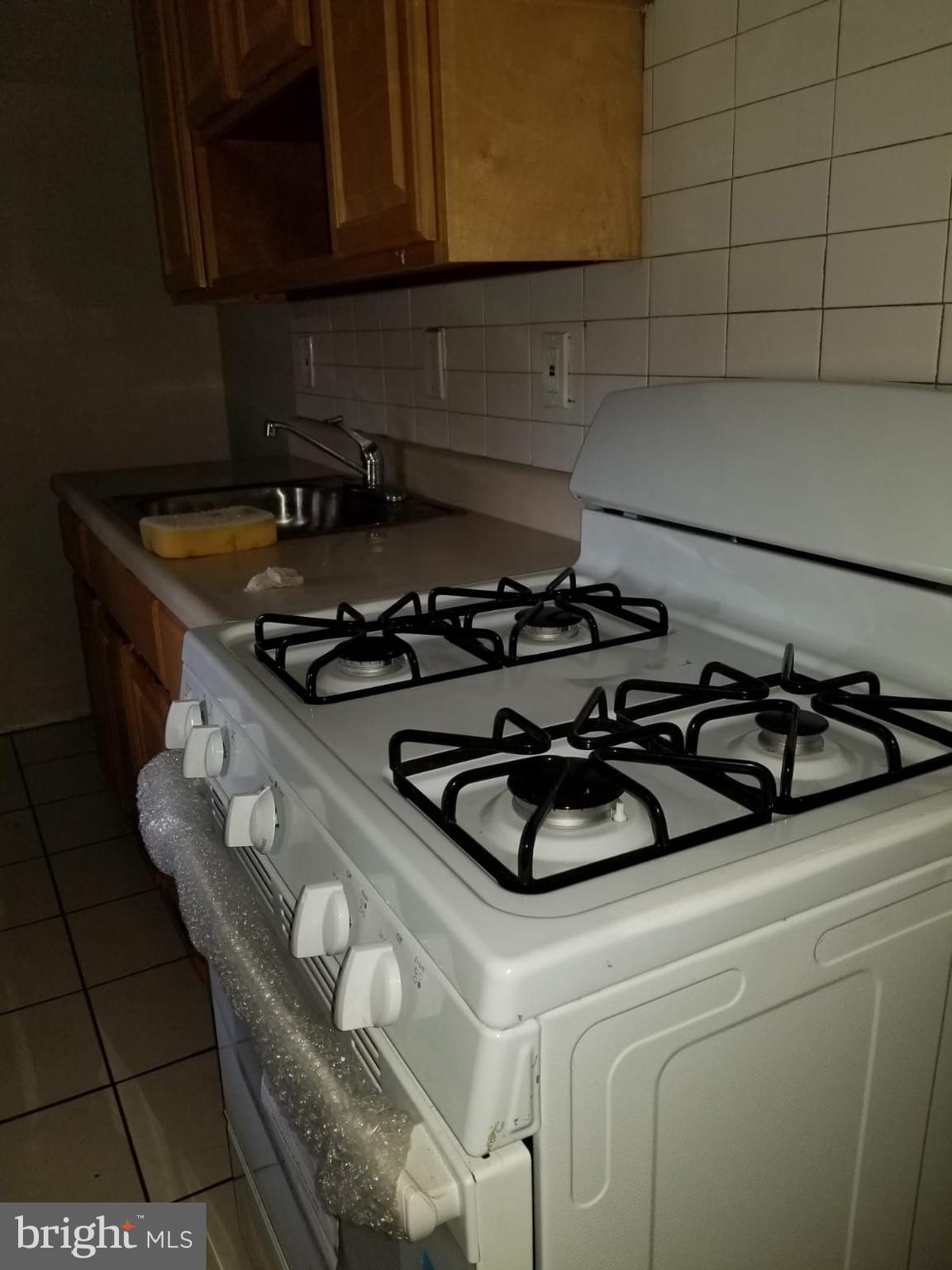 1264 Decatur Street Camden, NJ 08104 - Photo 8 of 9 a kitchen with a sink a stove and cabinets