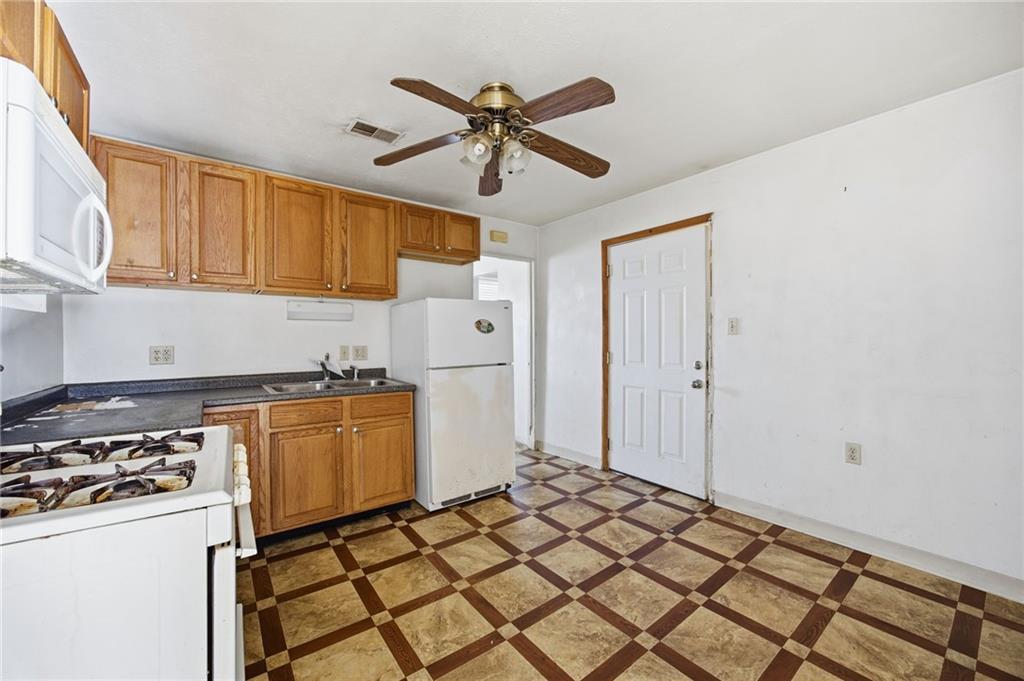 1450 Fleming Avenue McKees Rocks, PA 15136 - Photo 6 of 29 a kitchen with a refrigerator a stove and white cabinets