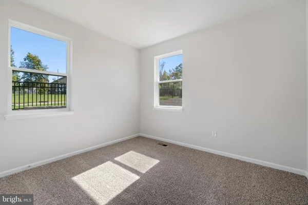 an empty room with windows and small kitchen