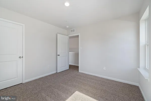 an empty room with windows and closet